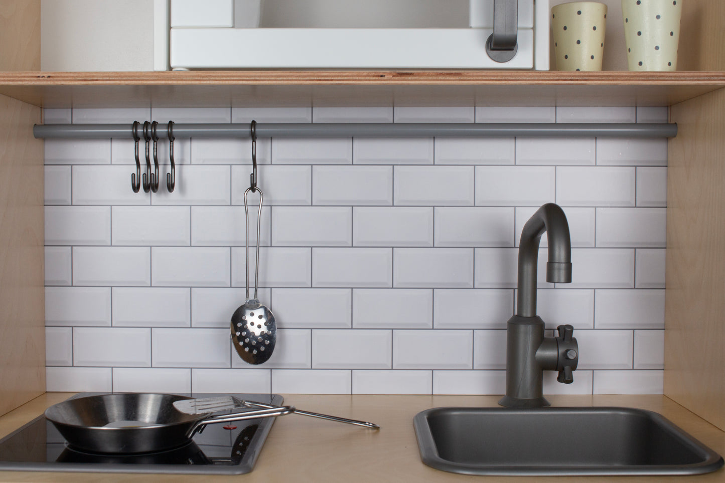 Details van witte tegelsticker Metro Muro op houten kinderkeukentje IKEA Duktig