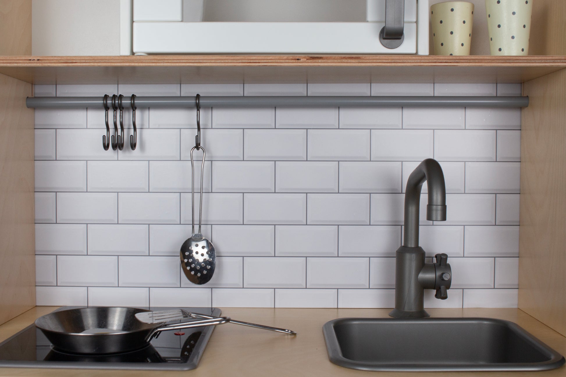 Details van witte tegelsticker Metro Muro op houten kinderkeukentje IKEA Duktig